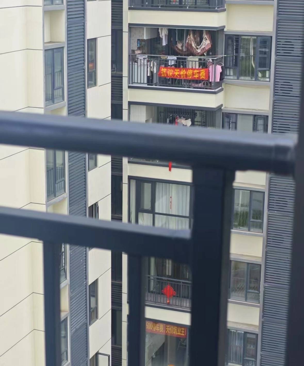 皇冠信用盘登3_广州一小区有住户阳台挂横幅抗议“天价”停车费皇冠信用盘登3,回应:每月450元,属正常价格